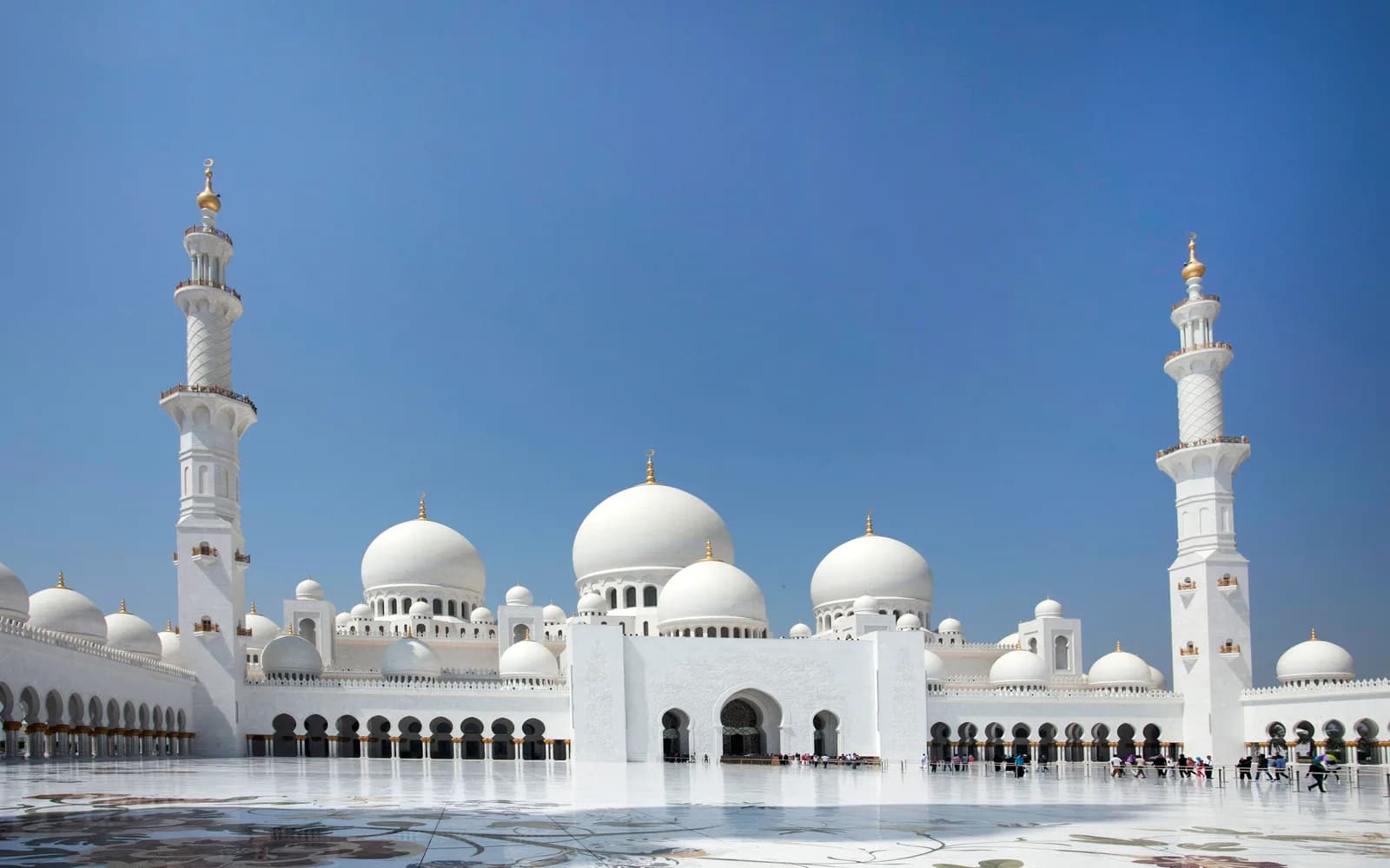 Abu Dhabi'deki Sheikh Zayed Büyük Camii'nin beyaz kubbeleri ve minareleri, berrak mavi gökyüzü