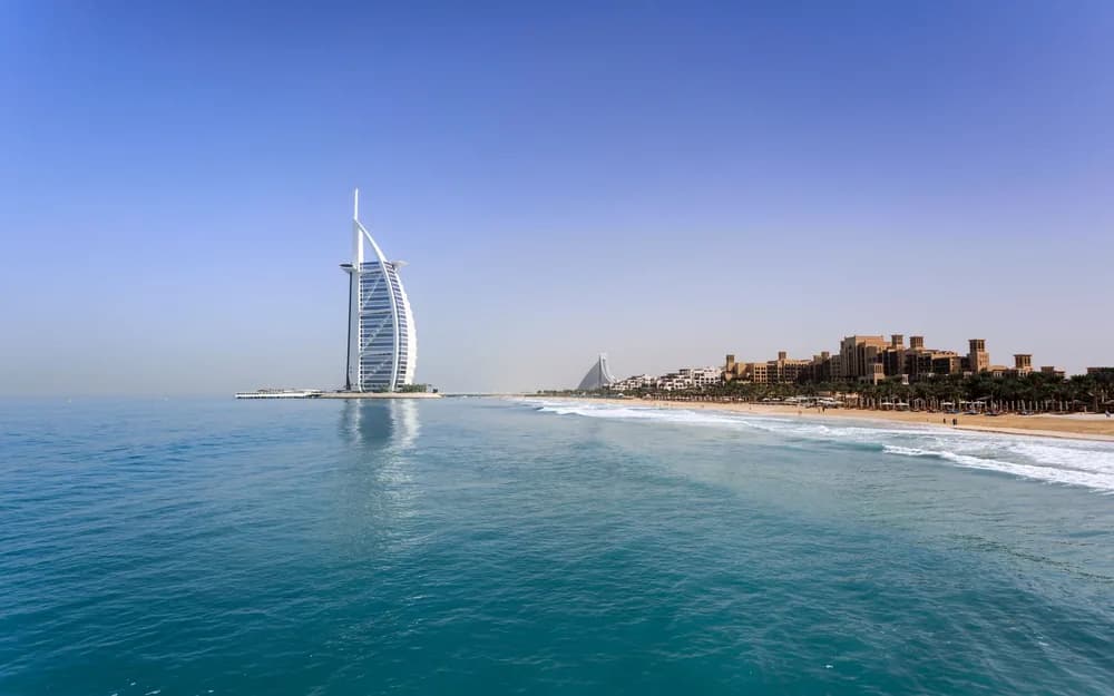Jumeirah plajından görülen Burj Al Arab oteli, turkuaz deniz ve açık renk kum
