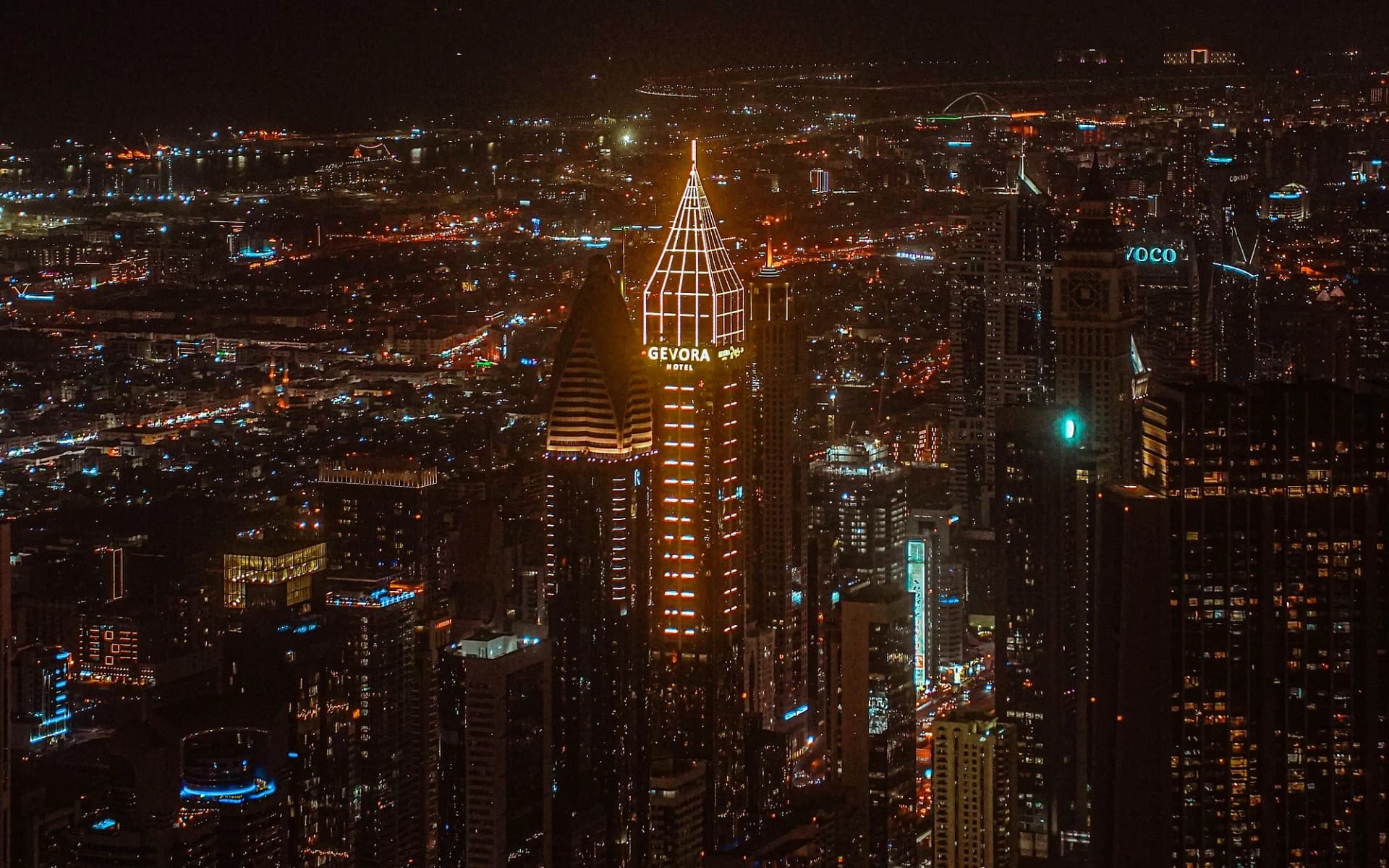 Gece Dubai silüeti ve ışıklandırılmış Gevora Hotel kulesi