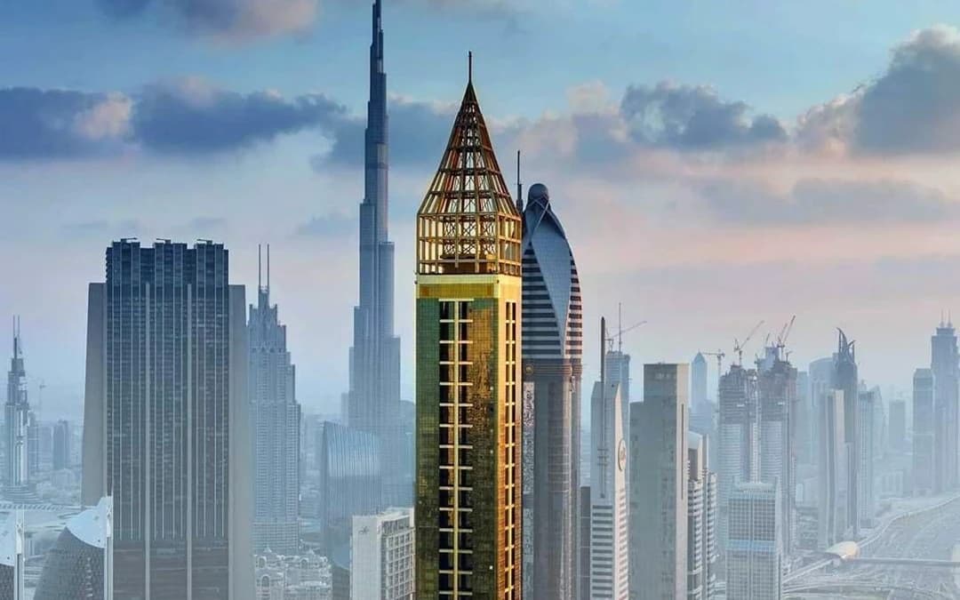 Gün doğumunda altın rengi Gevora Hotel kulesi ve arkada Burj Khalifa